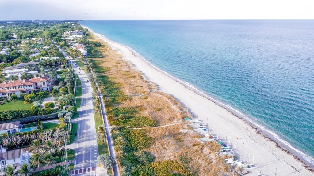 a beach with a road and buildings along it